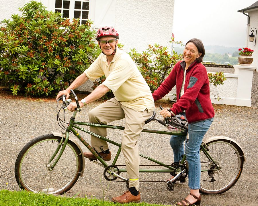 man and woman on a tandem bicycle in the grounds of Clos Mirabel