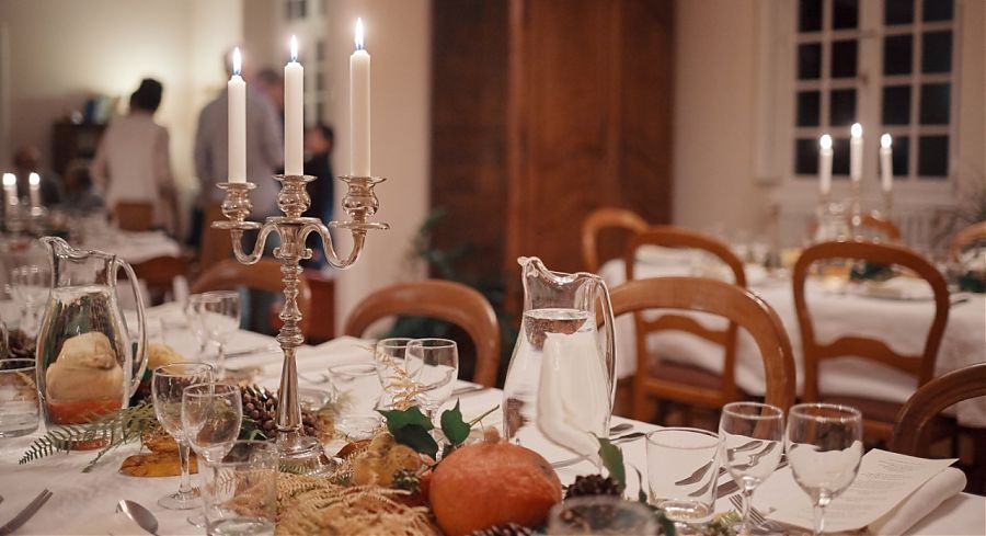 Table with candles, glasses and knives and forks.