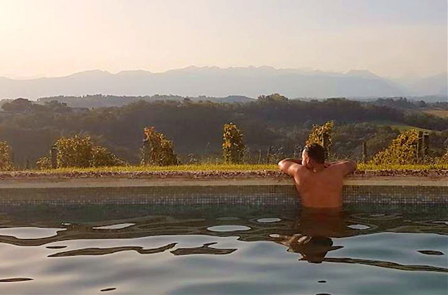 Man in swimming pool looking at mountain view.