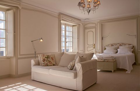 The Master bedroom with white sofa and kingsized bed.